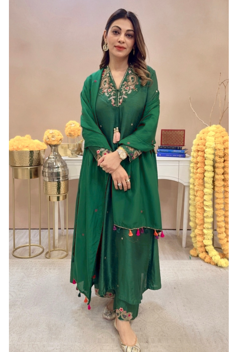 A woman wearing a green V-neck pocket paisley adhira kurta set with embroidery on the neck pockets and cuffs, and a paisley border on the lower kurta. The set is completed with a dupatta which is not visible in the image.