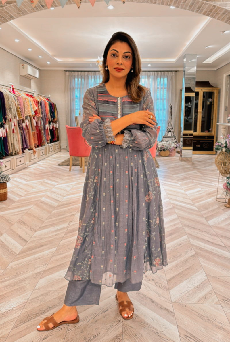 Model showcasing Meghna Nayyar blue threadwork kurta set with pleats and lace details in a stylish boutique.